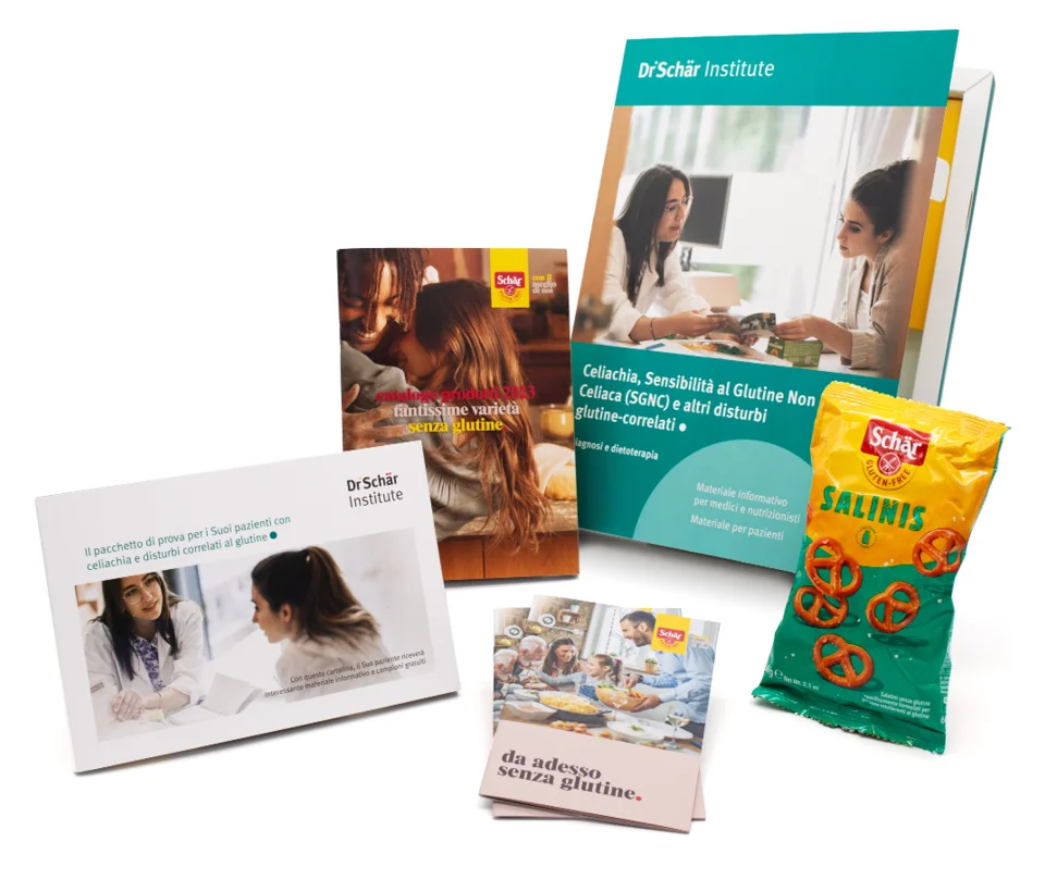 Una raccolta di materiali educativi tra cui un manuale, opuscoli e snack su una superficie bianca