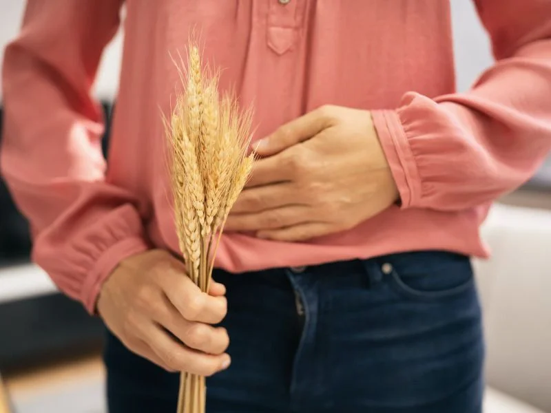 Mujer con dolor de tripa sujetando trigo