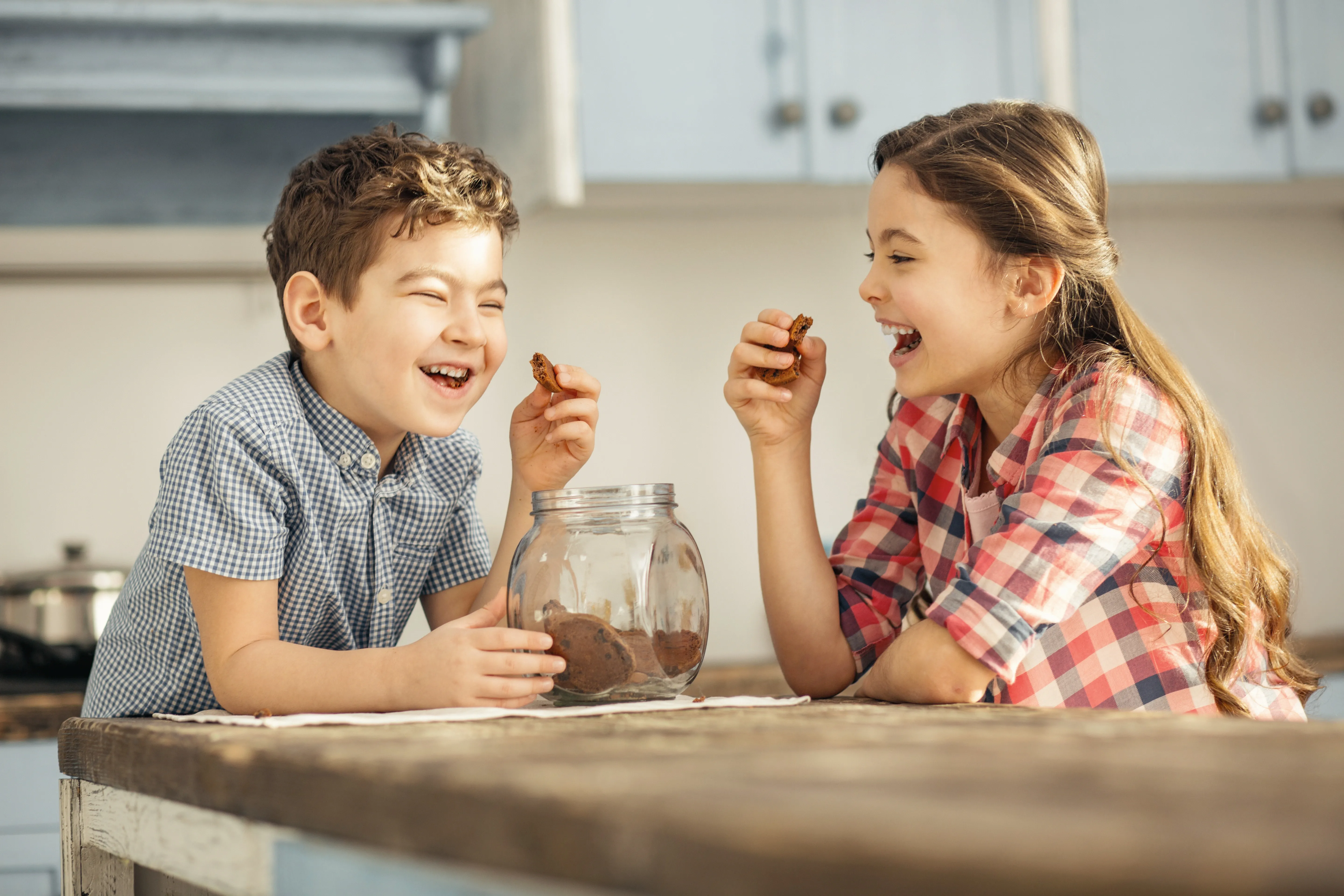 dos niños comiendo galletas y riendo