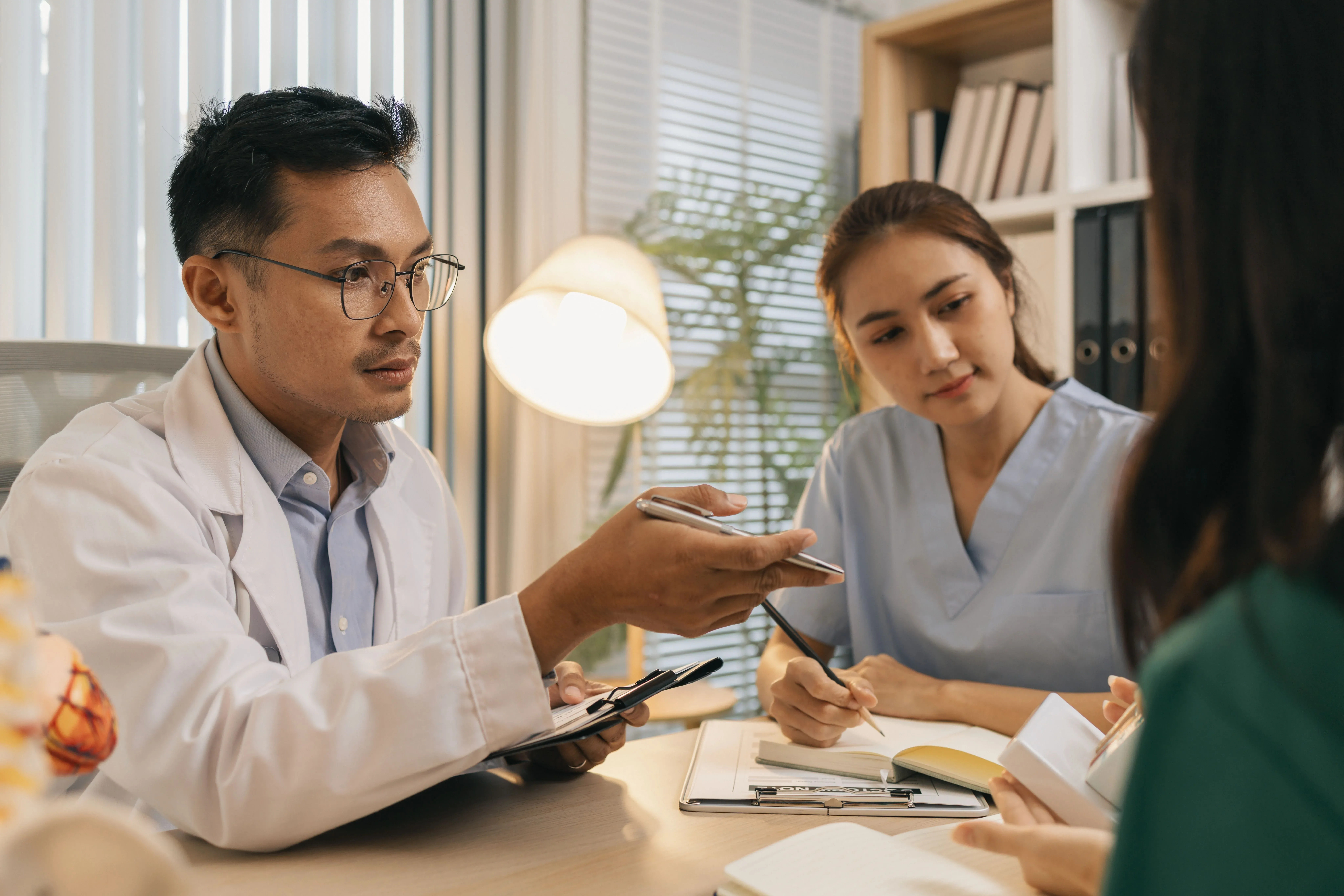 médico y enfermera en consulta con un paciente