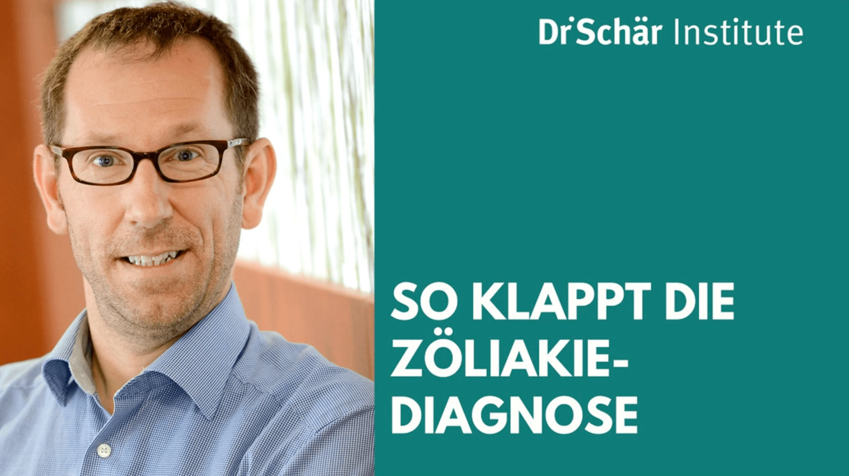 Ein Mann mit Brille lächelt, trägt ein blaues Hemd, vor einem verschwommenen Hintergrund mit Pflanzen